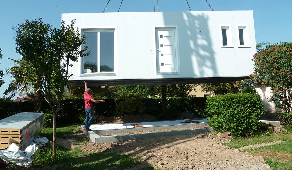 Le studio est déposé par une grue dans le jardin.