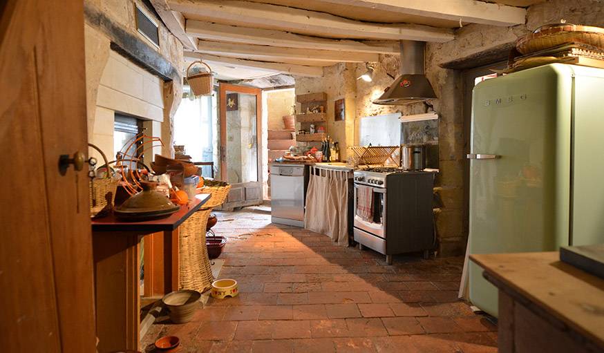 Cuisine avec, au sol, des tomettes d'origine. Les trois chats et le chien s'y retrouvent pour manger.