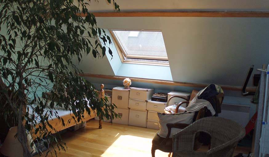 Le lit et les boîtes de rangement dans l'ancienne chambre d'amis.