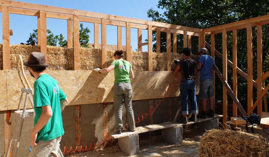 Les bénévoles sur le chantier en train de garnir l'ossature en bois.