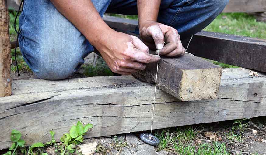 Le fil à plomb permet de tracer des repères sur le bois.