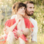 Un couple qui s'enlace dans l'herbe au coucher du soleil