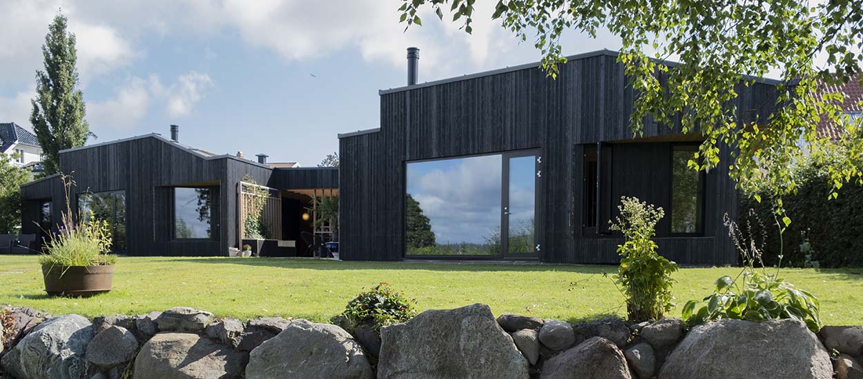 Tout seul, il construit sa maison moderne en bois brûlé