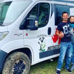 Un jeune couple pose devant son van aménagé