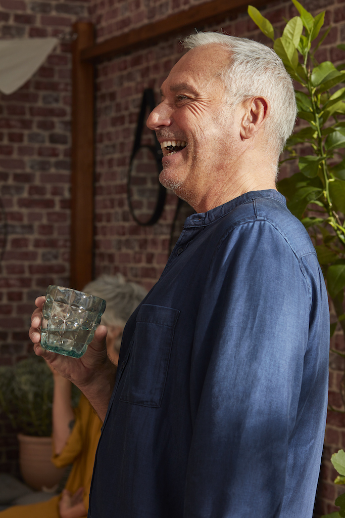 homme avec un verre qui rigole