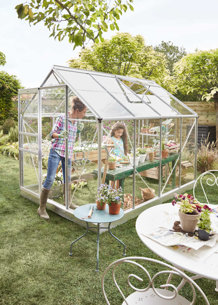 Serre avec mère et fille qui jardinent