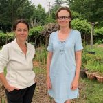 deux amies posent devant leur jardin et potager partagé