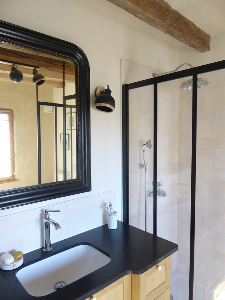 Une salle de bains restaurée avec un meuble vasque en beau granit noir