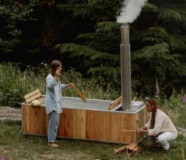 Cette baignoire d'extérieure chauffée au feu de bois permet de se détendre en pleine nature