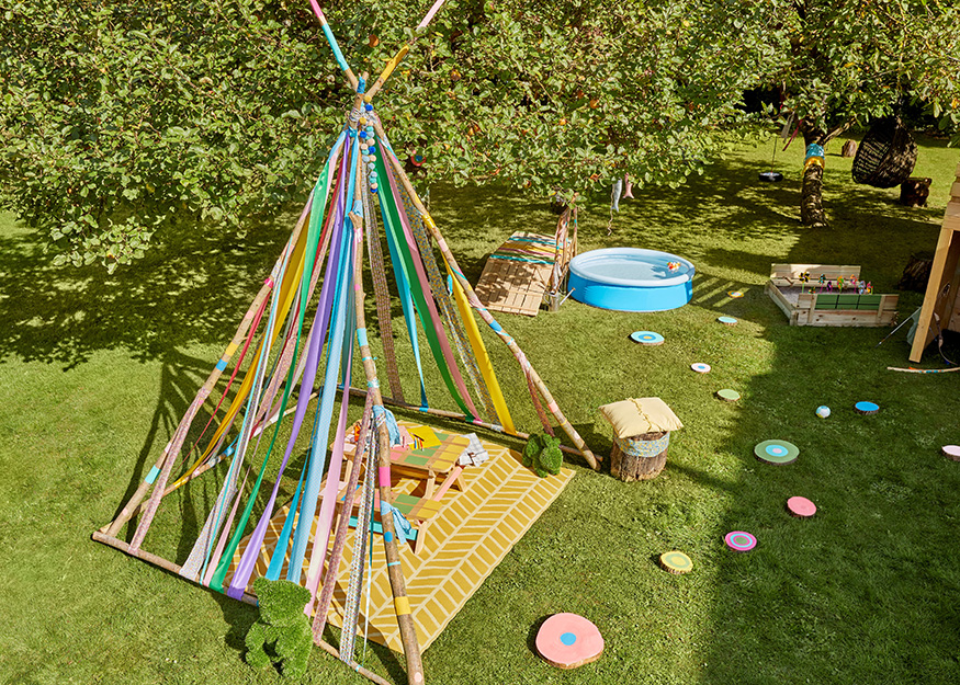 Un tipi d'extérieur pour un jardin, réalisé avec des branches et du tissu