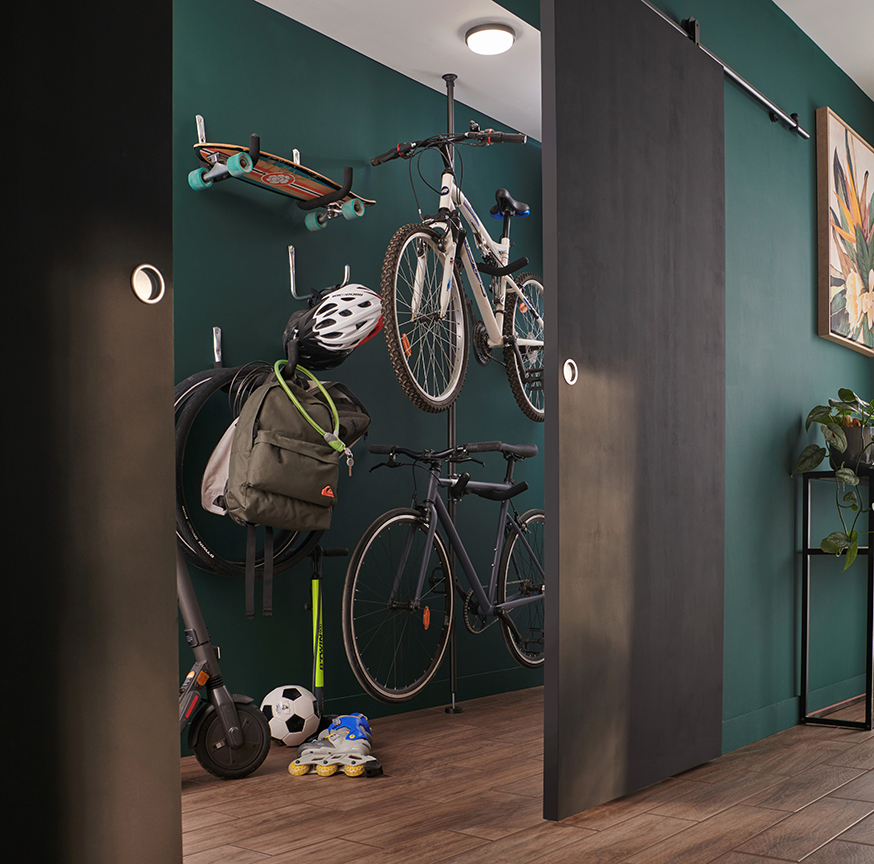 Des vélos rangés dans un couloir sur le mur et au plafond