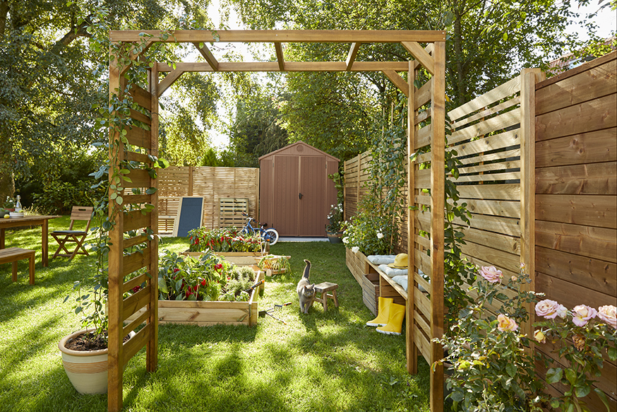 un jardin très frais avec des arbres et des carrés potagers en bois