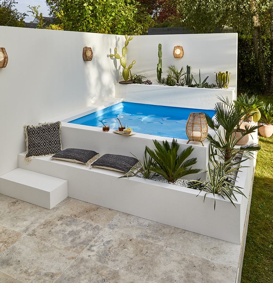 une piscine blanche dans un jardin