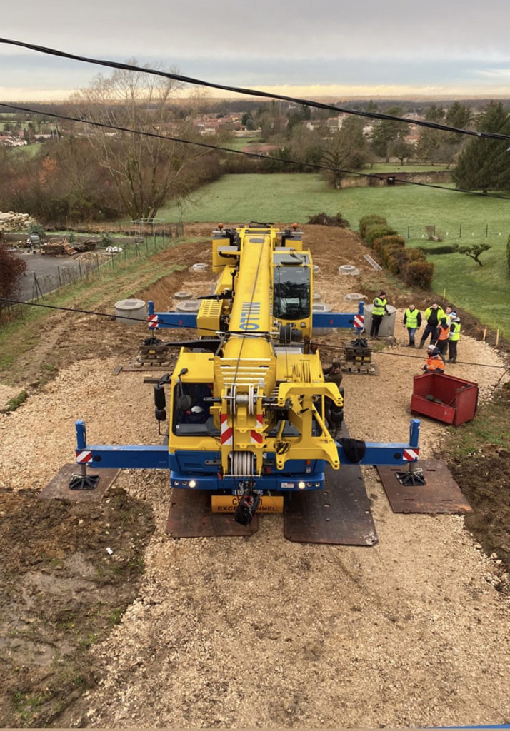 Une machine installe les fondations d'une maison en containers